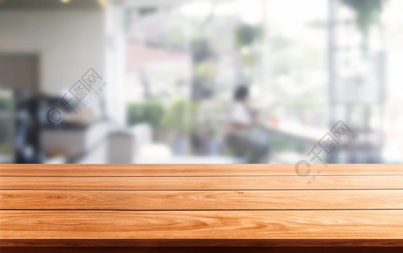 木桌在现代餐馆室或咖啡店模糊的背景中与空的拷贝空间在桌上产品显示
